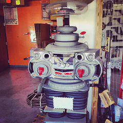 Photo of a 1960s-style robot with oval head made of clear glass