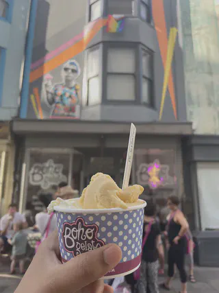 An gelato in a tub with a spoon held up in front of the Boho Gelato shop front in the Poole Valley, Brighton