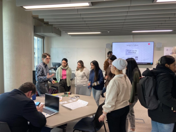 Fiona is using the Smithery and John V Willshire's Regenerative Design Field Kit with a group of students in a symposium style space with large tables.