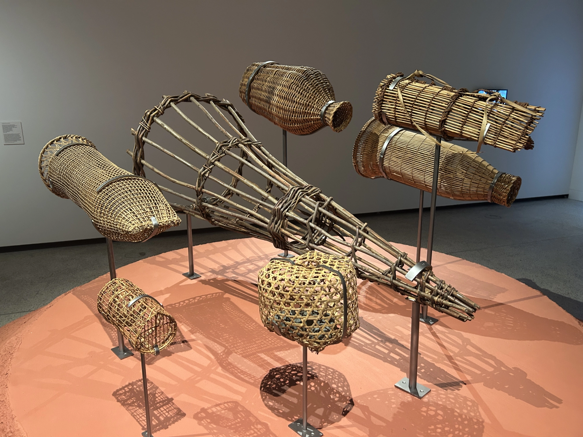 an array of basket-like objects displayed on stands above a plinth, they are different shapes and sizes designed to different varieties of adult fish